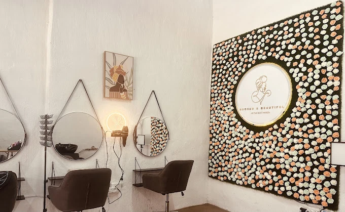 Inside Booked and Beautiful: styling stations with round mirrors and the floral logo wall, Willow Park Manor salon interior
